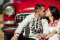 Beautiful bride and elegant stylish groom  kissing near retro car with tender feelings, concept of love and life Royalty Free Stock Photo