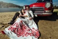 Beautiful bride and elegant stylish groom sitting near retro car with tender feelings, concept of love and life Royalty Free Stock Photo