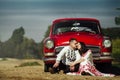 Beautiful bride and elegant stylish groom sitting near retro car with tender feelings, concept of love and life Royalty Free Stock Photo