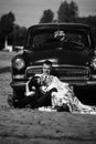 Beautiful bride and elegant stylish groom sitting near retro car with tender feelings, concept of love and life Royalty Free Stock Photo