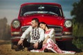 Beautiful bride and elegant stylish groom sitting near retro car with tender feelings, concept of love and life Royalty Free Stock Photo