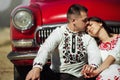 Beautiful bride and elegant stylish groom sitting near retro car with tender feelings, concept of love and life Royalty Free Stock Photo