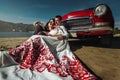 Beautiful bride and elegant stylish groom sitting near retro car with tender feelings, concept of love and life Royalty Free Stock Photo