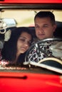 Beautiful bride and elegant stylish groom sitting in retro car with tender feelings, concept of love and life Royalty Free Stock Photo