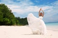 Beautiful bride in elegant wedding dress posing on beach in Thailand