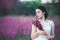 Beautiful bride in a flower field. The girl in a white dress with a bouquet in a summer field at sunset Royalty Free Stock Photo