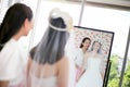 Beautiful bride getting dressed by her best friend in her wedding day and choosing a wedding dress in the shop and the shop Royalty Free Stock Photo