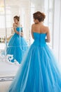 Beautiful bride in gorgeous blue dress Cinderella style near mirror Royalty Free Stock Photo