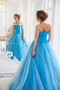 Beautiful bride in gorgeous blue dress Cinderella style near mirror Royalty Free Stock Photo