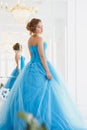 Beautiful bride in gorgeous blue dress Cinderella style near mirror