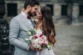 Beautiful bride and groom embracing and kissing on their wedding day outdoors Royalty Free Stock Photo