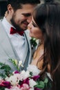 Beautiful bride and groom embracing and kissing on their wedding day outdoors Royalty Free Stock Photo