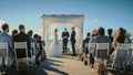 Beautiful Bride and Groom During an Outdoors Wedding Ceremony on a Beach Near the Ocean. Perfect Royalty Free Stock Photo