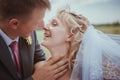 Beautiful bride and groom standing in grass and kissing. Wedding couple fashion shoot. Royalty Free Stock Photo