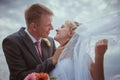 Beautiful bride and groom standing in grass and kissing. Wedding couple fashion shoot. Royalty Free Stock Photo