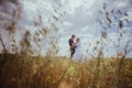 Beautiful bride and groom standing in grass and kissing. Wedding couple fashion shoot. Royalty Free Stock Photo