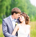 Beautiful bride and groom standing in grass and kissing. Wedding couple Royalty Free Stock Photo