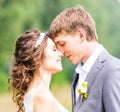 Beautiful bride and groom standing in grass and kissing. Wedding couple Royalty Free Stock Photo