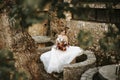Beautiful bride with her bouquet sititng in the garden Royalty Free Stock Photo