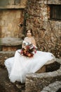 Beautiful bride with her bouquet sititng in the garden Royalty Free Stock Photo