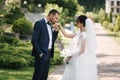 Beautiful bride with her handsome groom walking outside on theri wedding day. Happy newlyweds