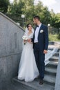 Beautiful bride with her handsome groom walking outside on theri wedding day. Happy newlyweds