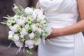 Beautiful bride in her wedding dress with a white bouquet of roses in her hands Royalty Free Stock Photo