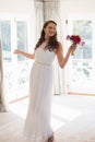 Beautiful bride holding bouquet looking away at home Royalty Free Stock Photo