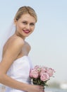 Beautiful Bride Holding Flower Bouquet Against Clear Blue Sky Royalty Free Stock Photo