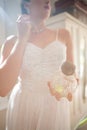 Beautiful bride holding perfume while wearing earring at home Royalty Free Stock Photo