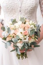 Beautiful bride is holding a wedding colorful bouquet. Beauty of colored flowers. Close-up bunch of florets. Bridal accessories. F Royalty Free Stock Photo