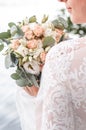 Beautiful bride is holding a wedding colorful bouquet. Beauty of colored flowers. Close-up bunch of florets. Bridal Royalty Free Stock Photo