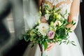 Beautiful bride is holding a wedding colorful bouquet. Royalty Free Stock Photo