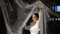 A bride in a white dress plays with a veil. Turkmen bride. A beautiful bride holds a veil in her hands. Happy beautiful Royalty Free Stock Photo