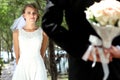 Beautiful bride looking at her groom hiding a bouquet Royalty Free Stock Photo