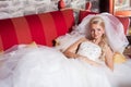 Beautiful bride lying on red sofa