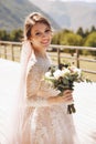 Beautiful bride in a nice dress stands on the terasse with great mountain view in Georgia Royalty Free Stock Photo