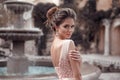 Beautiful bride with pearl earrings jewelry wears pink prom dress. Outdoor romantic portrait of Attractive brunette woman with