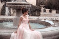 Beautiful bride in pink wedding dress. Outdoor romantic portrait of attractive brunette woman with hairstyle in prom dress with Royalty Free Stock Photo