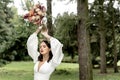 Beautiful bride posing in a wedding white dress holding a bridal bouquet over her head Royalty Free Stock Photo