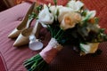 Beautiful bride`s shoes and perfume near lush wedding bouquet in blur