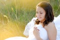 Beautiful bride smelling flower lying outdoors Royalty Free Stock Photo