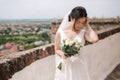 Beautiful bride stand in frind of city view with bouquet and smile Royalty Free Stock Photo