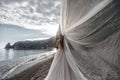 Beautiful bride in white dress posing on sea and mountains in background Royalty Free Stock Photo