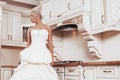 Beautiful bride stands in the kitchen