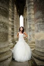 A beautiful bride stands next to the old church