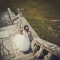 Beautiful bride stands on the stone stairs