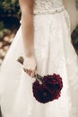 Beautiful bride in vintage white lace wedding dress holding fresh red flowers bouquet, hand with bouquet close-up, newlywed Royalty Free Stock Photo