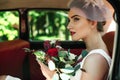 Beautiful bride with wedding bouquet sitting in car. Trendy bridal bouquet. Perfect bridal makeup and hairstyle. Stylish wedding. Royalty Free Stock Photo