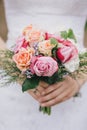 Beautiful bride in a wedding dress with bouquet and roses wreath posing in a green garden Royalty Free Stock Photo